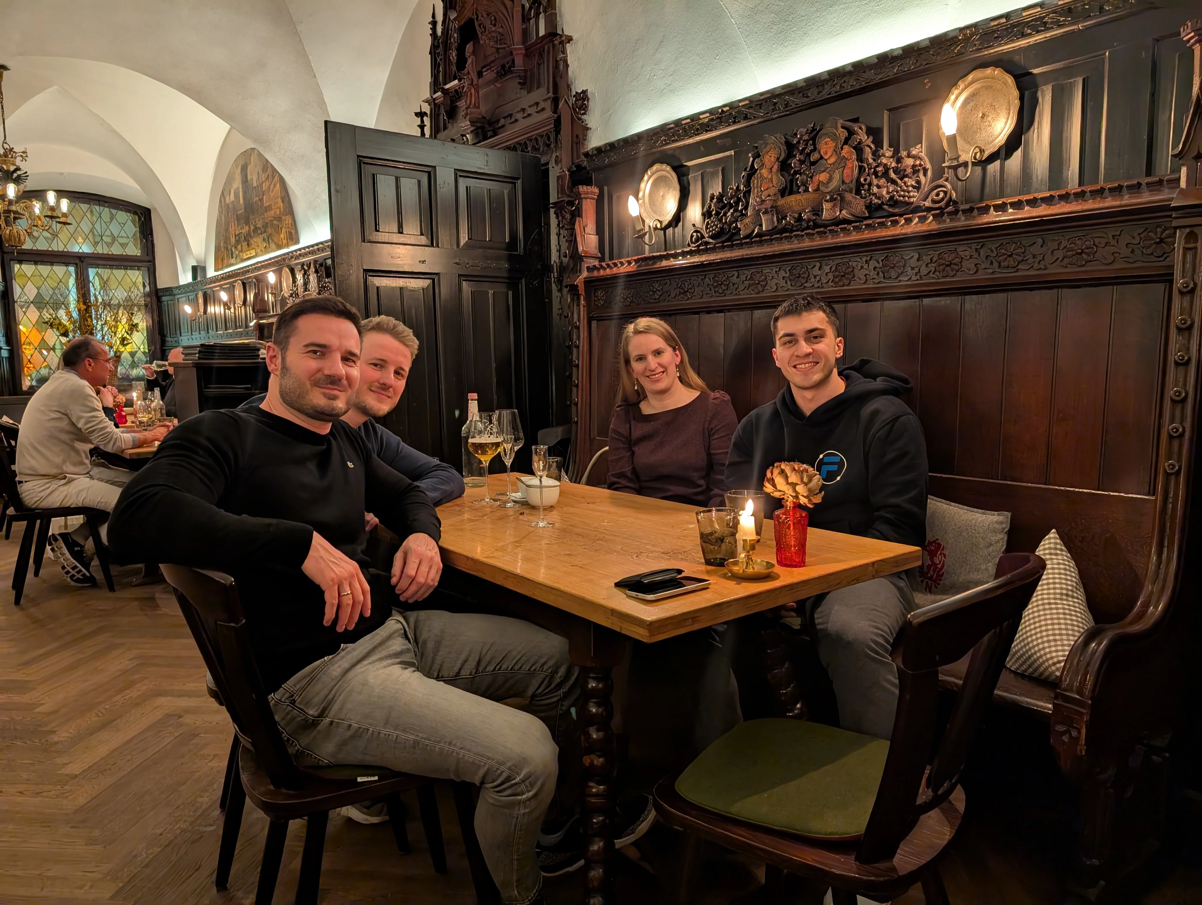 Mark at dinner in a wood-paneled German restaurant with Mark Weisbrod, Jakob Trost, and Sandra Kurze.